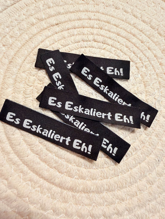 tolles neues Klapp Weblabel der Bienenkinder zum Einnähen mit dem Spruch Es eskaliert Eh! in schwarzer Ausführung