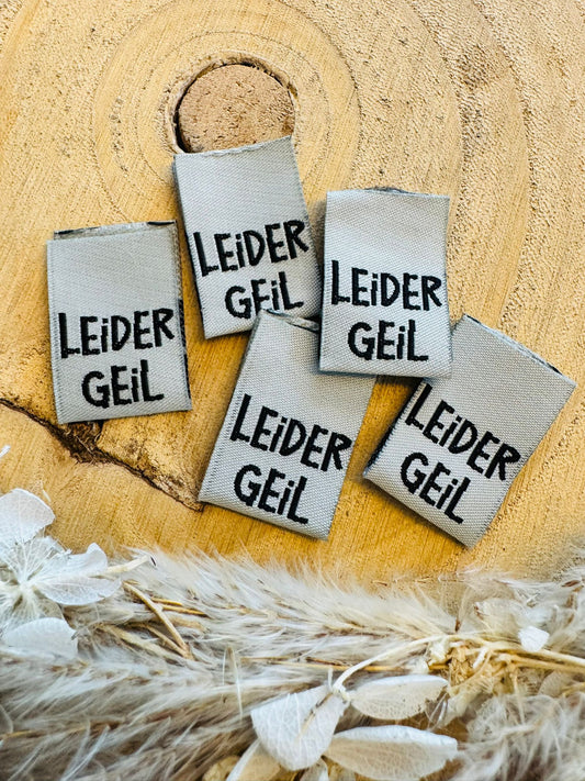 silbernes Weblabel mit dem Spruch Leider Geil in schwarzer Schrift