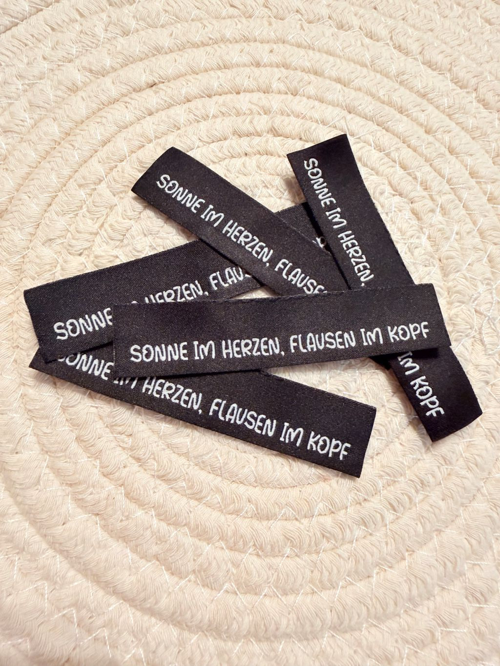 tolles neues Klapp Weblabel der Bienenkinder zum Einnähen mit dem Spruch "Sonne im Herzen, Flausen im Kopf" in schwarzer Ausführung