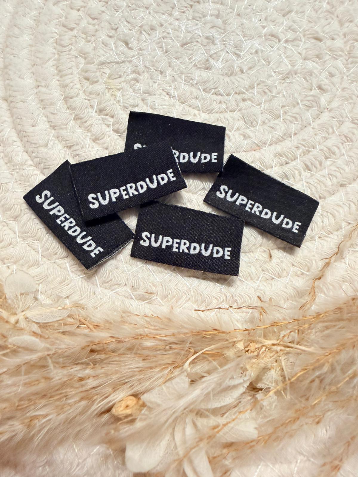 tolles neues Klapp Weblabel von Bienenkinder mit dem Spruch Superdude in schwarzer Ausführung