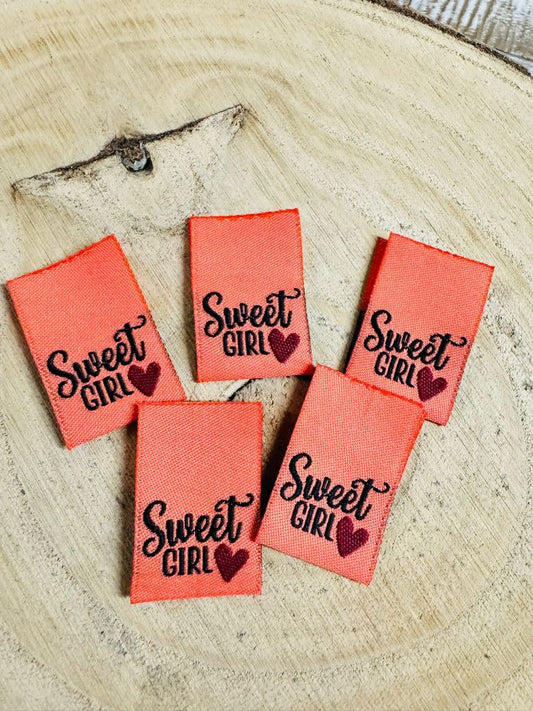 orangenes Weblabel mit dem Spruch Sweet Girl und einem kleinen Herzchen in schwarzer Schrift
