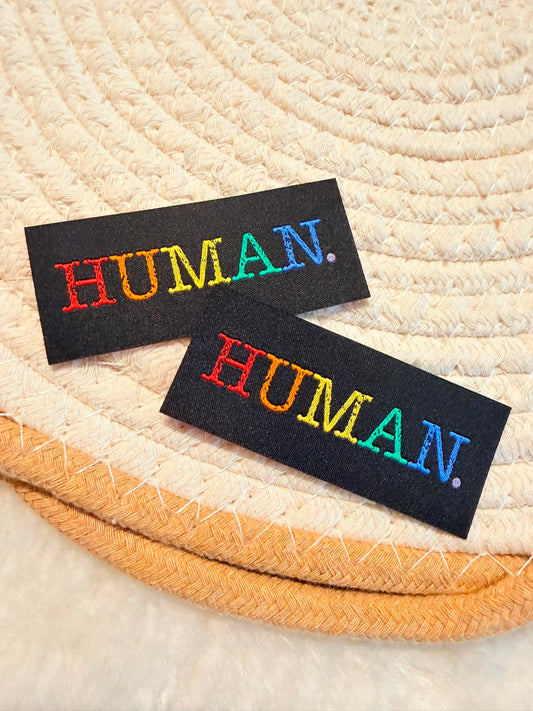 tolles Weblabel zum Aufbügeln mit dem Spruch Human in Regenbogen Farben